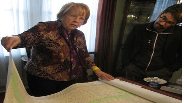 Two people reviewing a large printed map