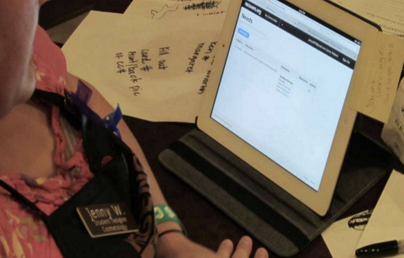 Person filling out a form on a tablet